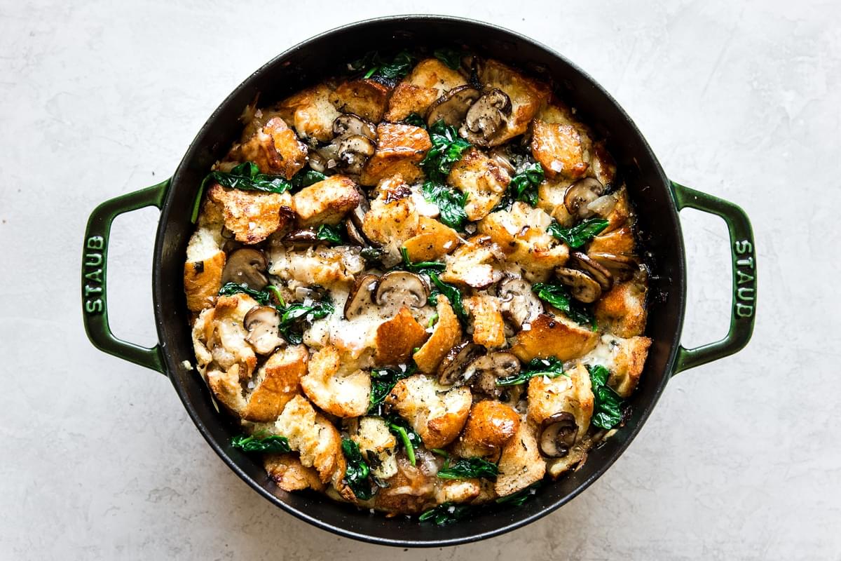 baked spinach mushroom strata in a green dutch oven