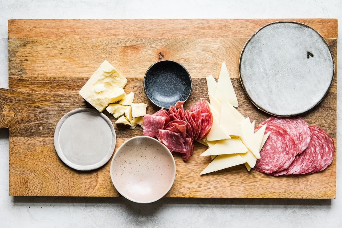 Maker’s Reserve aged cheddar on a cheese board with salami for the perfect cheese board.