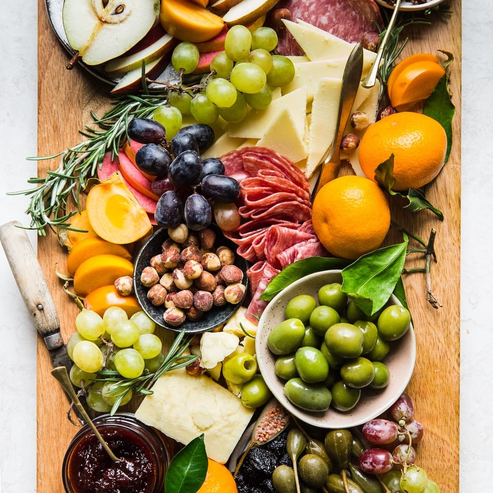 The Perfect Cheese Board with salami, grapes, olives and cheese