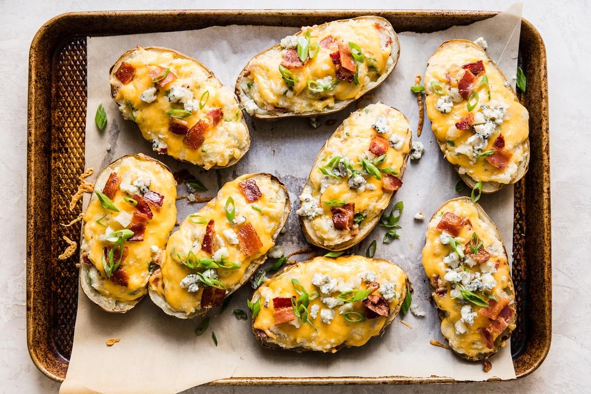 Twice baked potatoes topped with melted cheddar cheese, crispy bacon, fresh scallions, and blue cheese