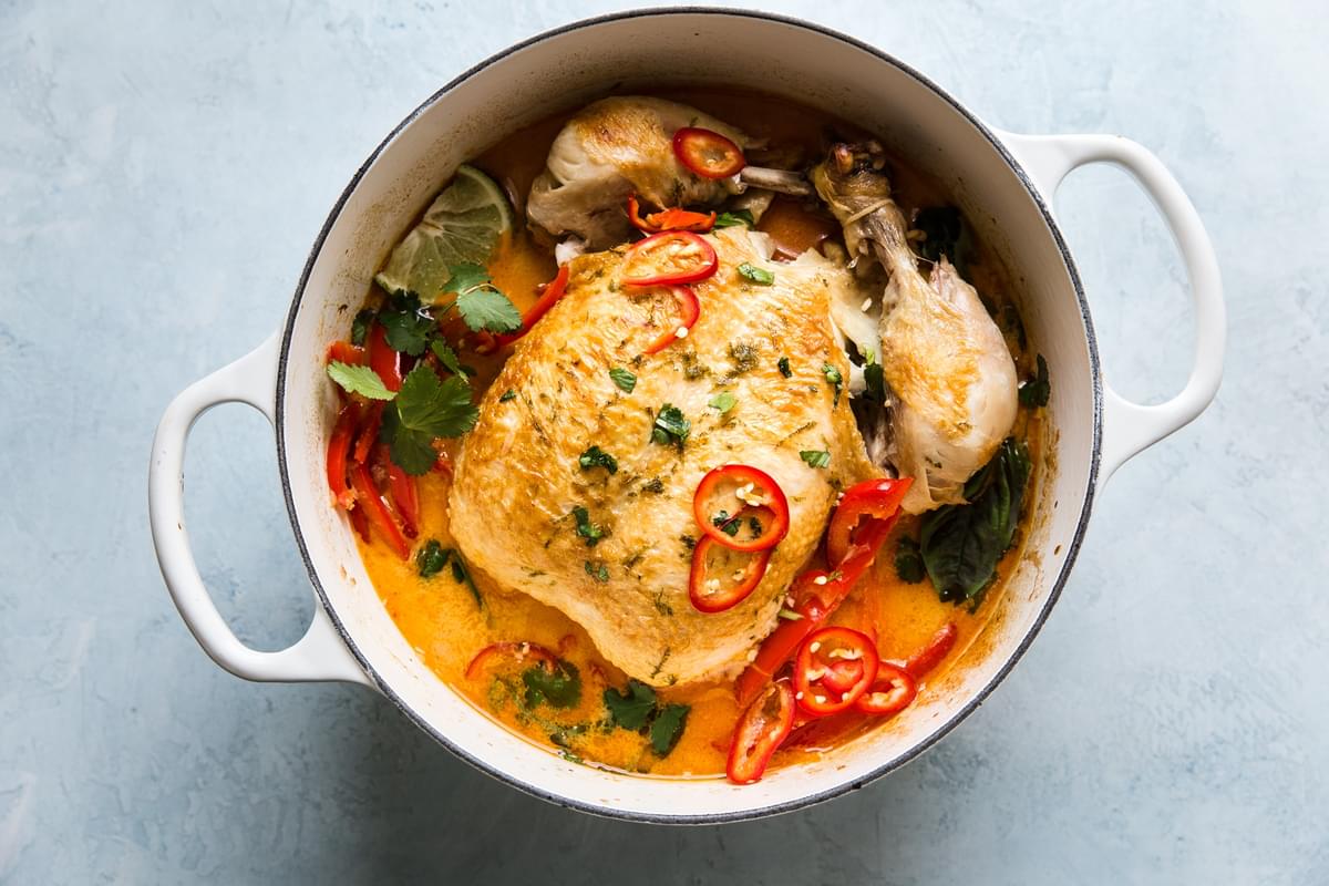 Whole poached chicken in coconut curry with peppers, onions, cilantro and Thai peppers