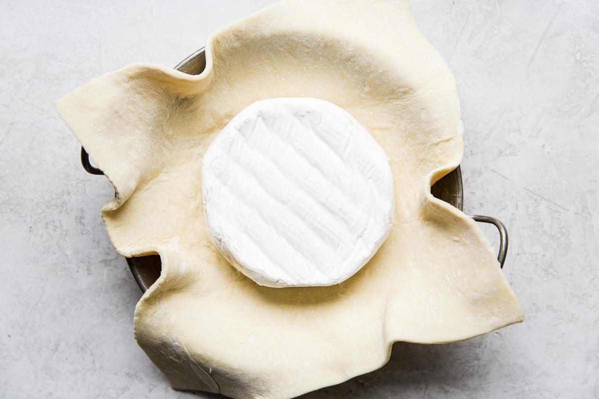 a wheel of brie on top of puff pastry in a baking dish