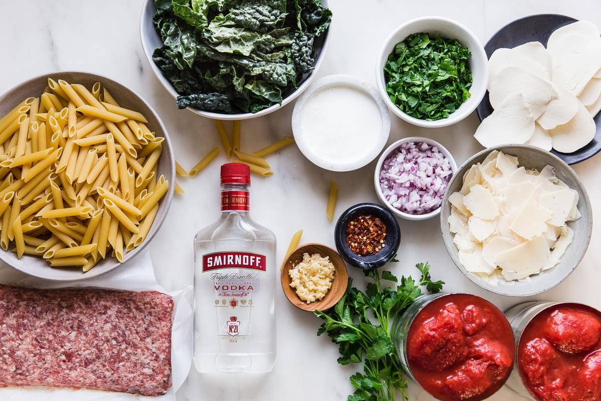 Ingredients laid out for Penne Alla Vodka with kale and fresh mozzarella tomatoes sausage