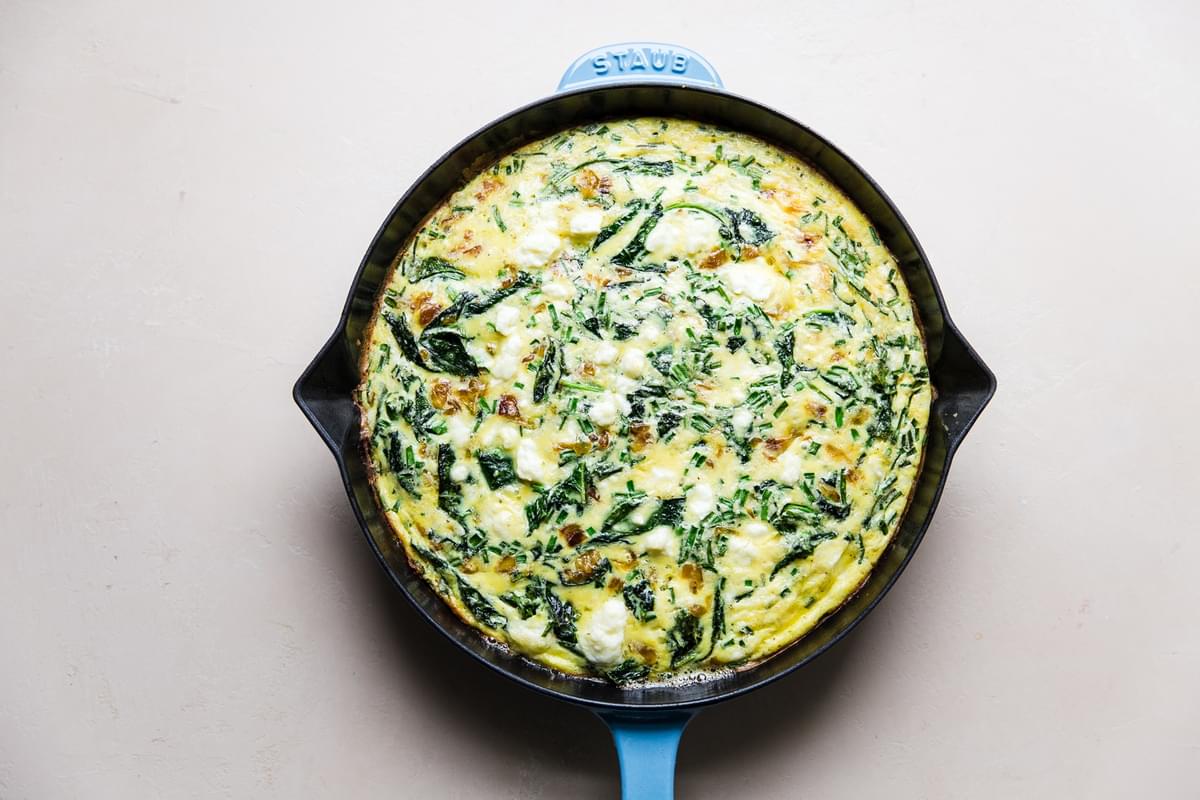 caramelized onion and kale frittata baked in a blue cast iron skillet