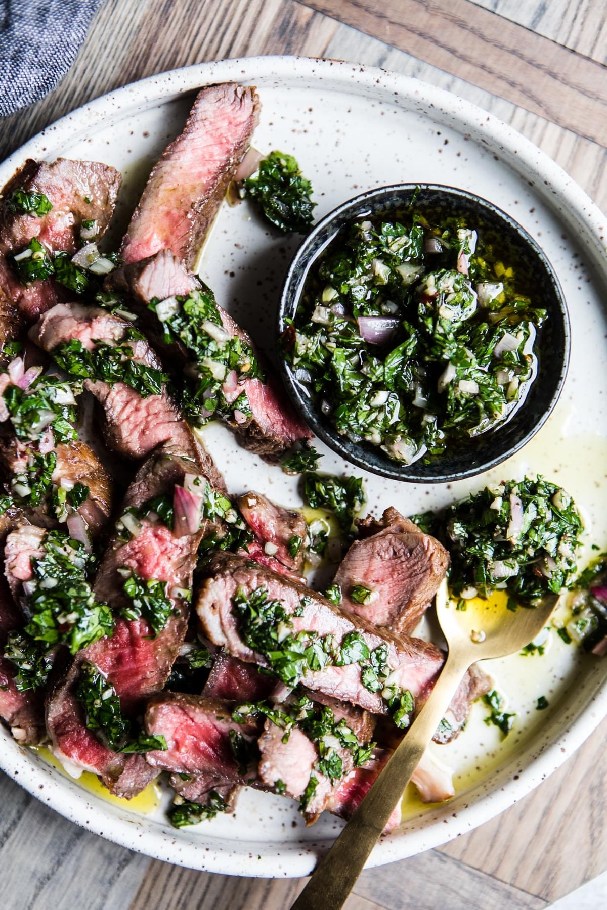 low carb dinner of sliced up steak served with homemade whole30 chimichurri