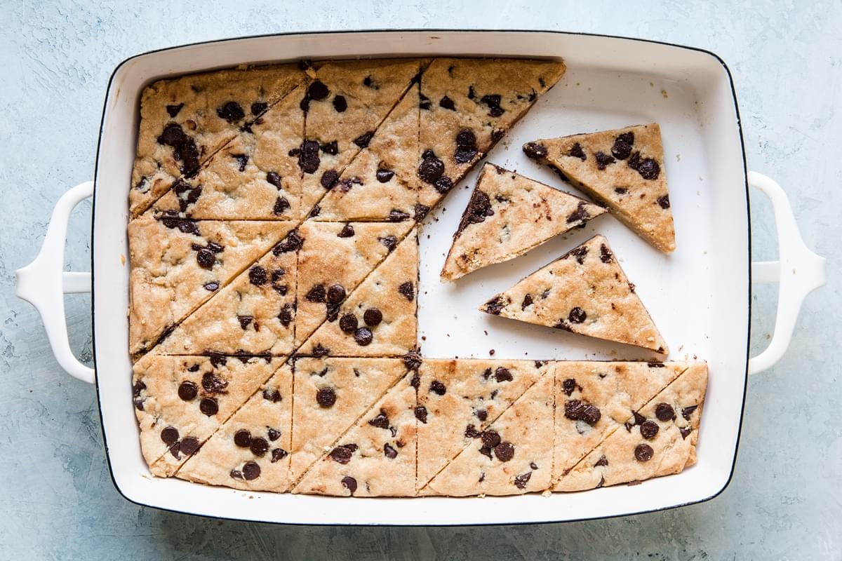 cookie brittle in a white baking sheet with triangles cut out of it