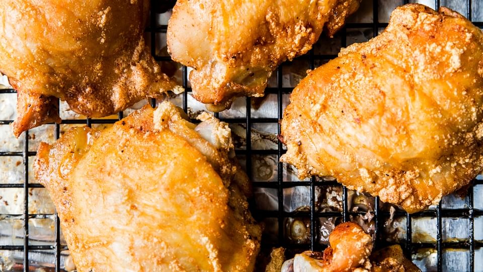 crispy skin-on bone in baked chicken thighs on a baking rack