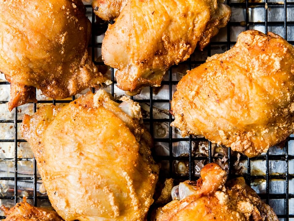 crispy skin-on bone in baked chicken thighs on a baking rack
