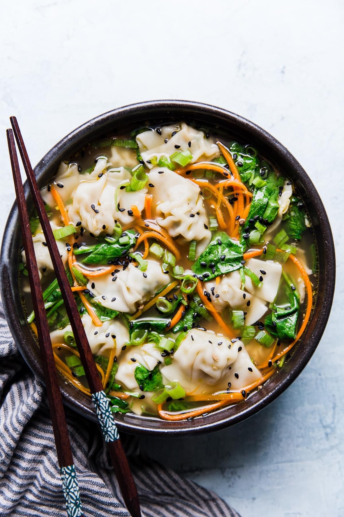 bowl of easy dumpling soup with chop sticks and a striped linen
