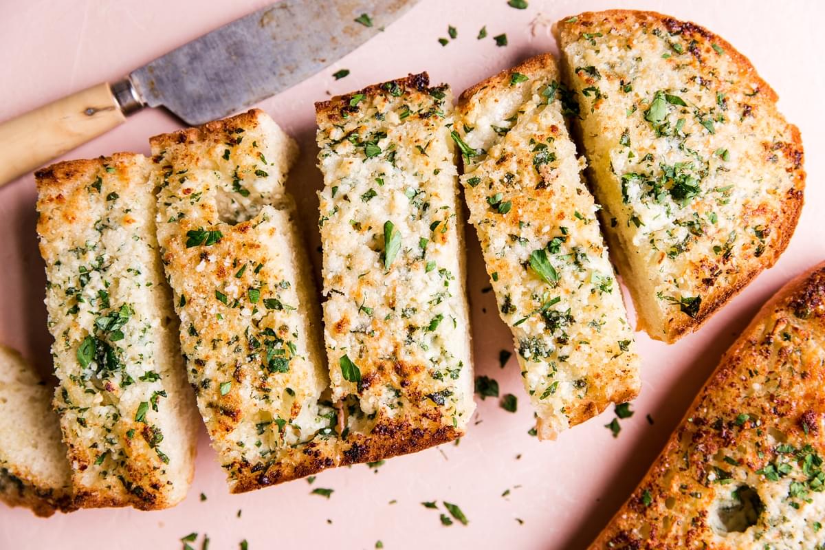 baked garlic bread cut up into slices with a knife