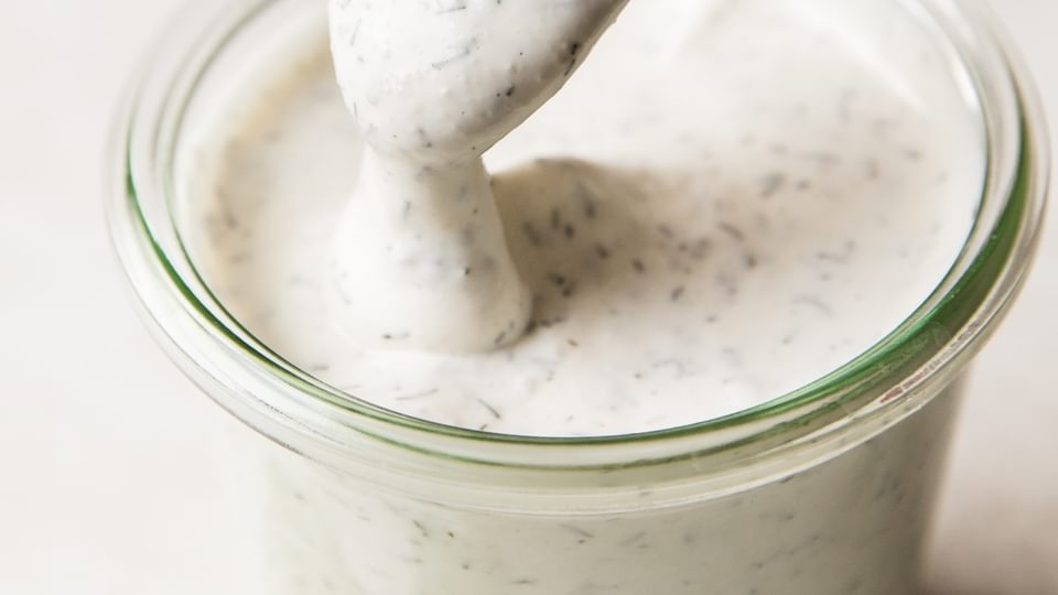 spoon dipped in jar of homemade buttermilk ranch dressing