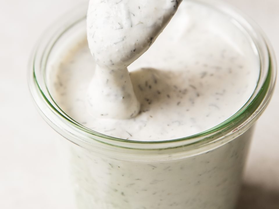 spoon dipped in jar of homemade buttermilk ranch dressing
