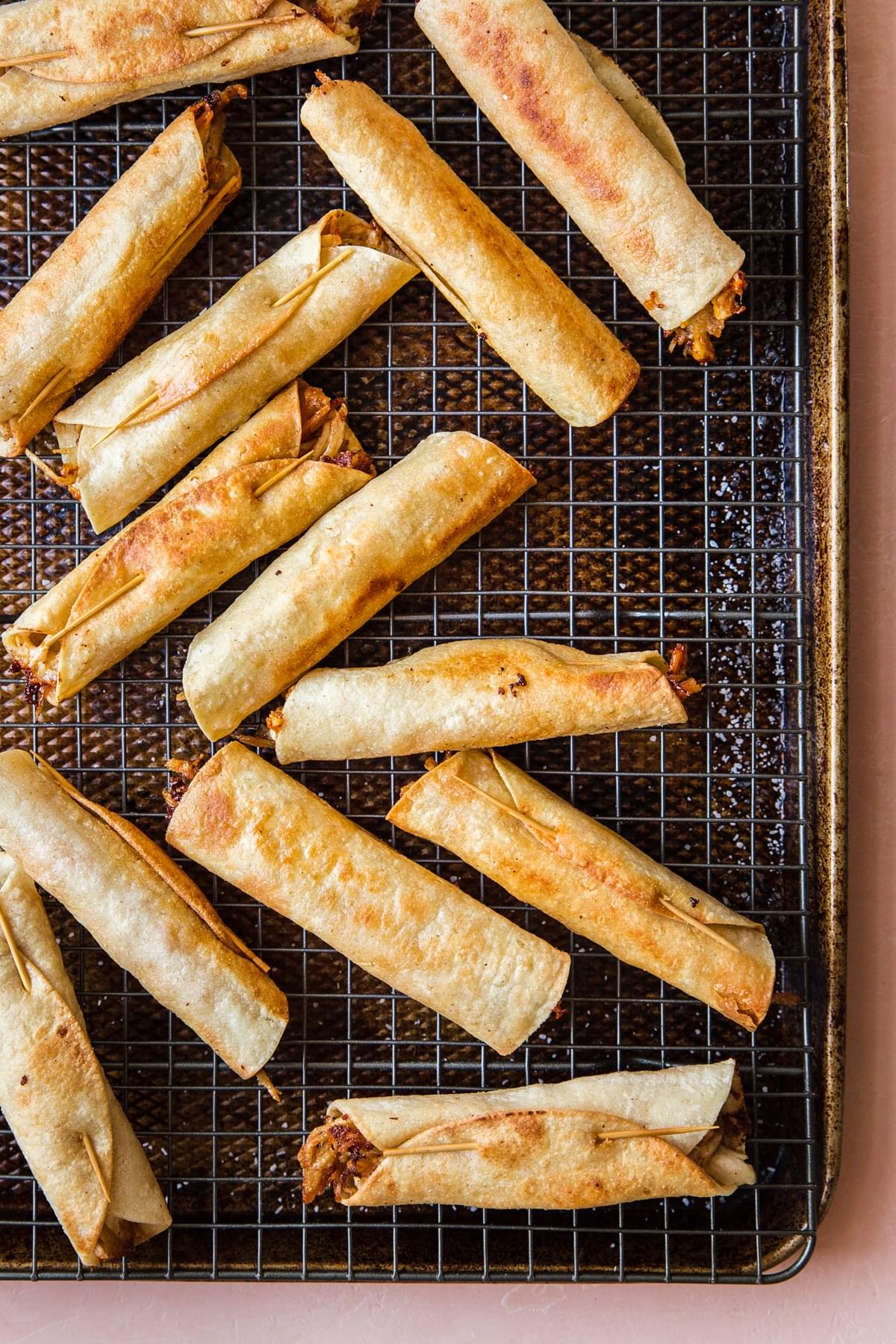 fried chicken taquitos on a baking sheet
