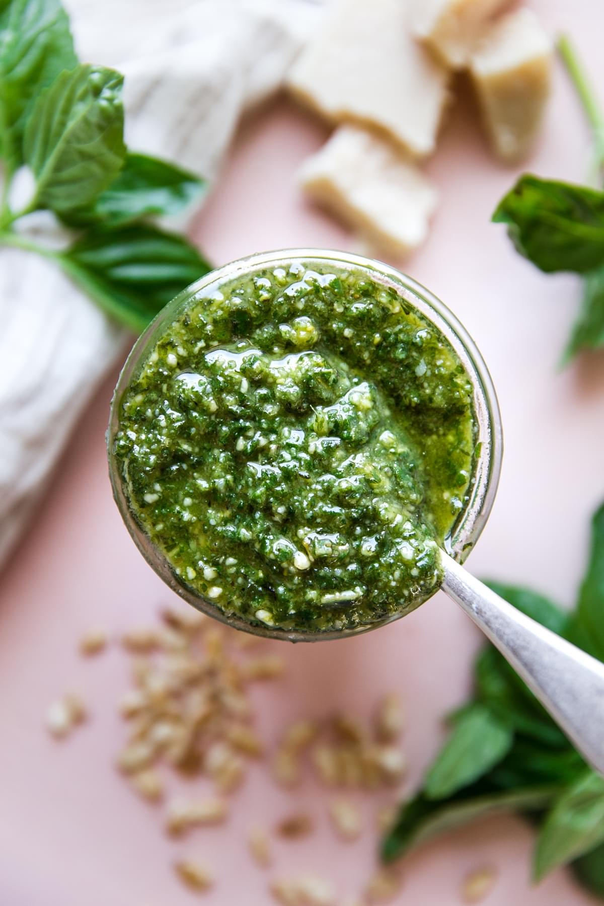 jar of homemade basil pesto with a spoon in it