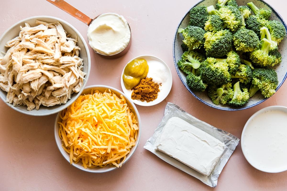 Ingredients laid out cheese, cream cheese, chicken,  mayonnaise, broccoli.