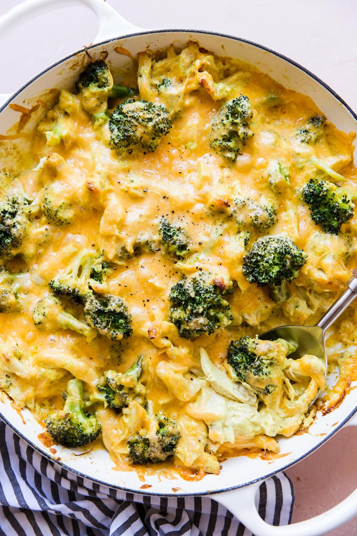 melted cheese over broccoli, shredded chicken, cheddar cheese, keto chicken divan in a pan