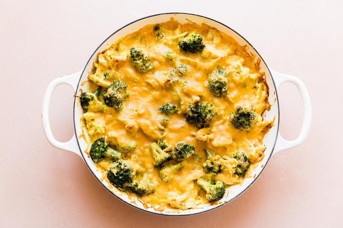 melted cheese over broccoli, shredded chicken, cheddar cheese, keto chicken divan in a pan