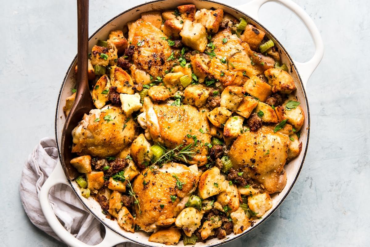large white skillet of chicken and stuffing casserole with sausage and fresh herbs
