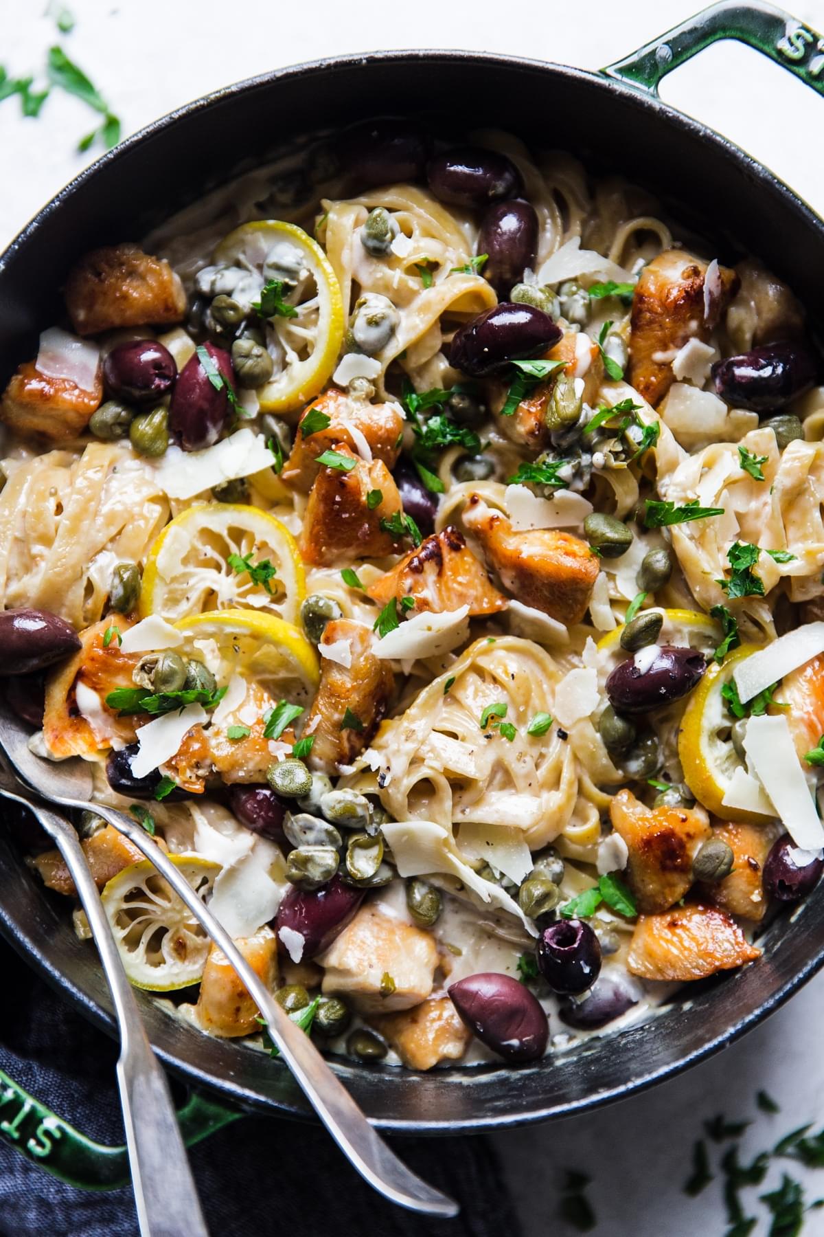 One Pot Creamy Mediterranean Chicken Pasta in a pot with a serving spoon