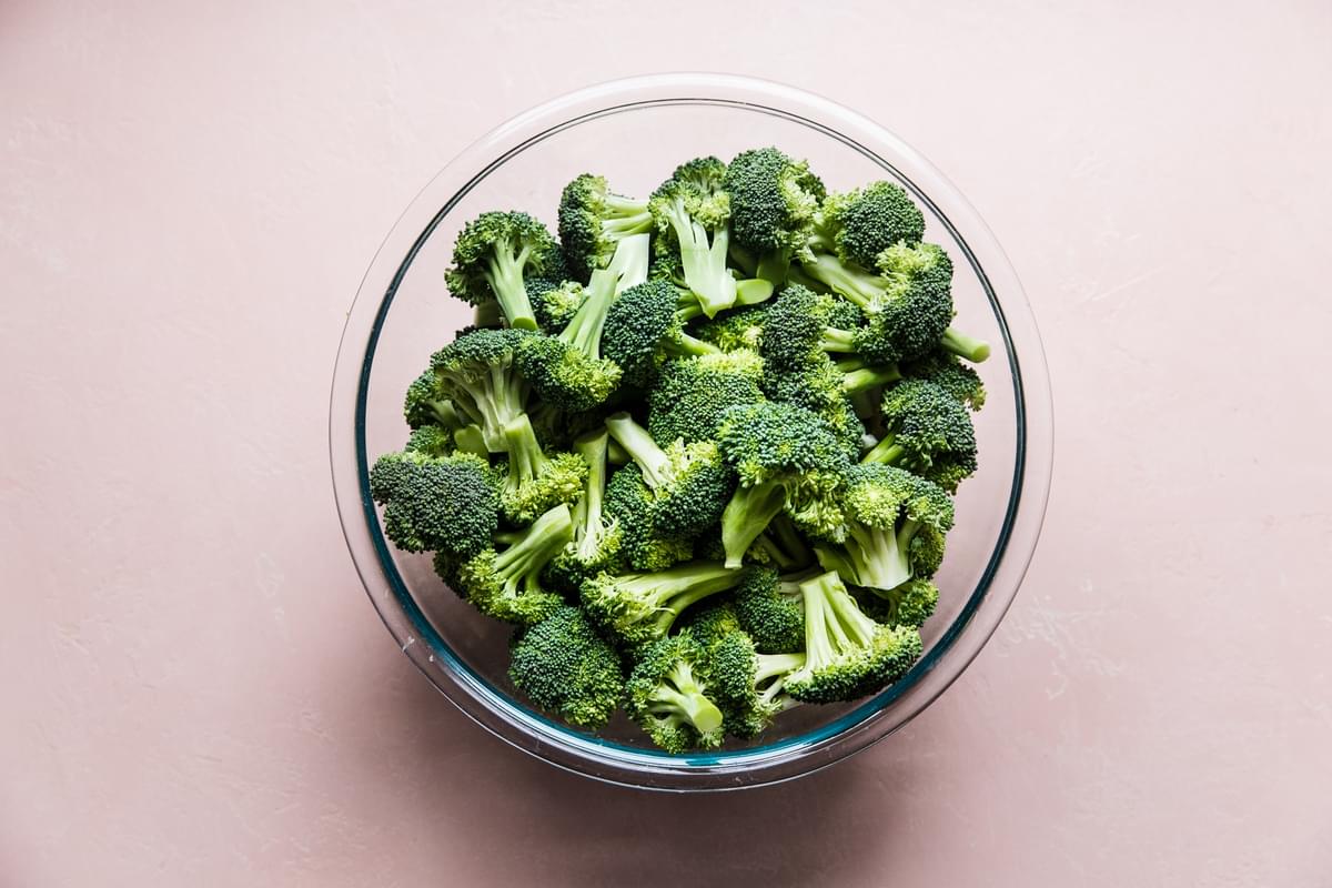 Large glass bowl filled with raw broccoli