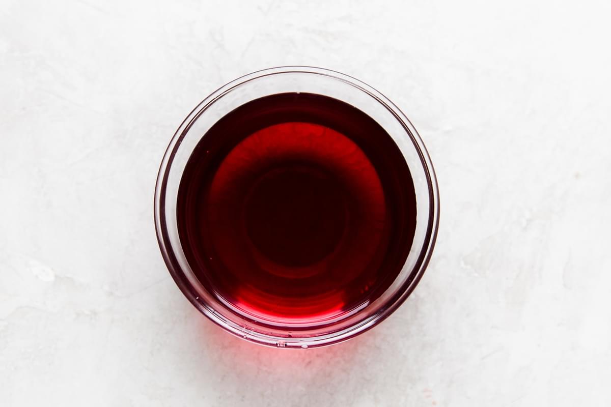 A glass bowl of red wine vinegar.