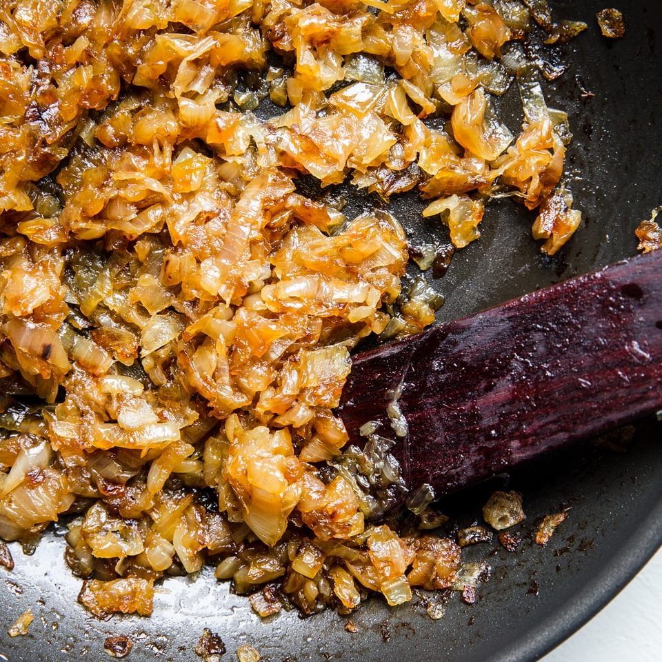 homemade caramelized onions being stirred in a pan
