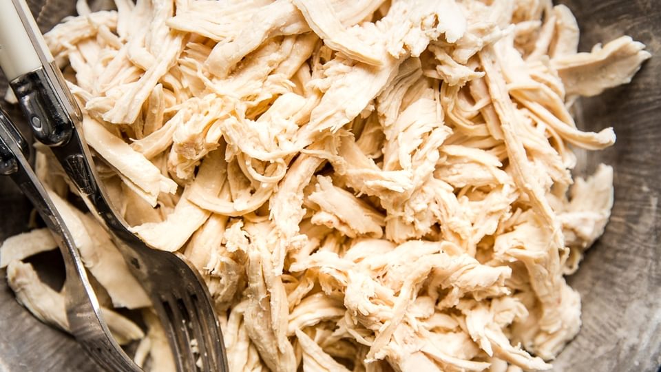 shredded chicken in a bowl with 2 forks