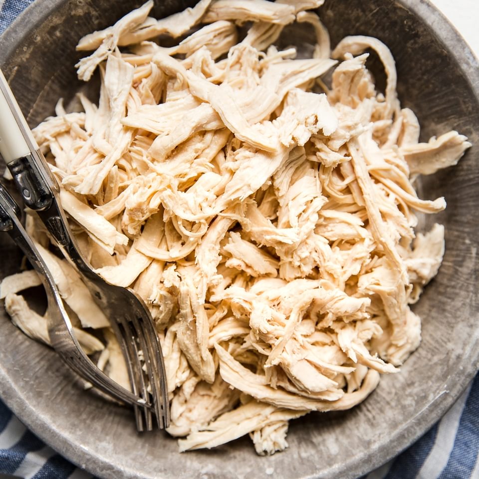 shredded chicken in a bowl with 2 forks