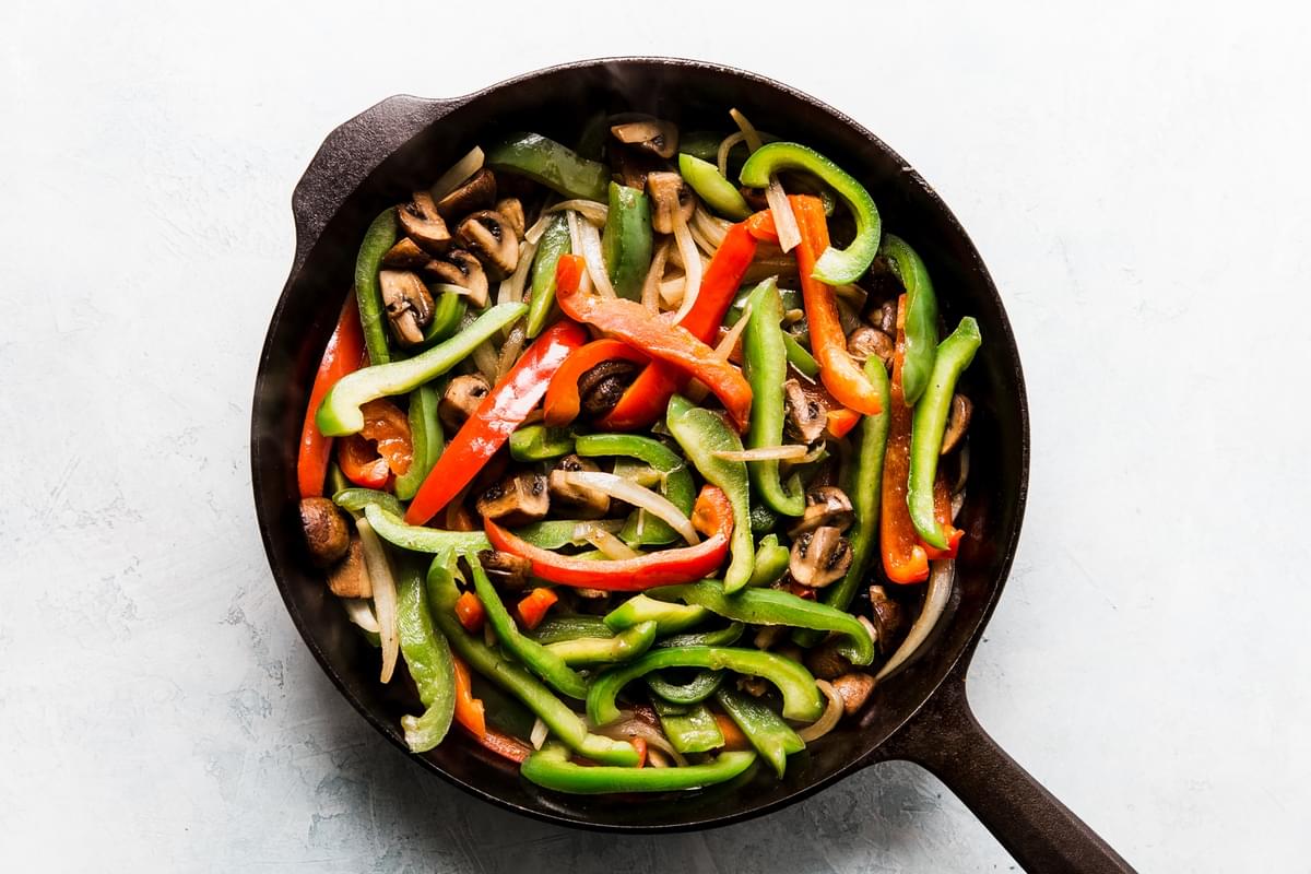 red and green bell peppers with steak in a pan