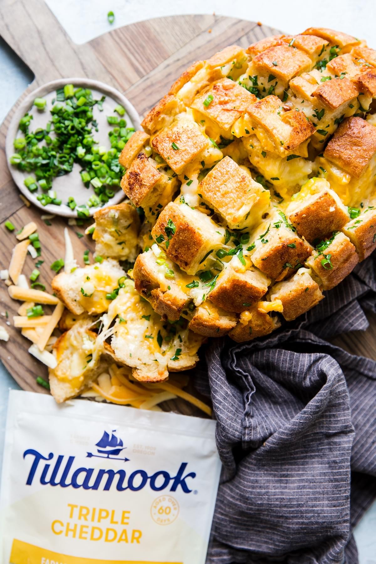 pull apart cheese bread on a cutting board with fresh green onions