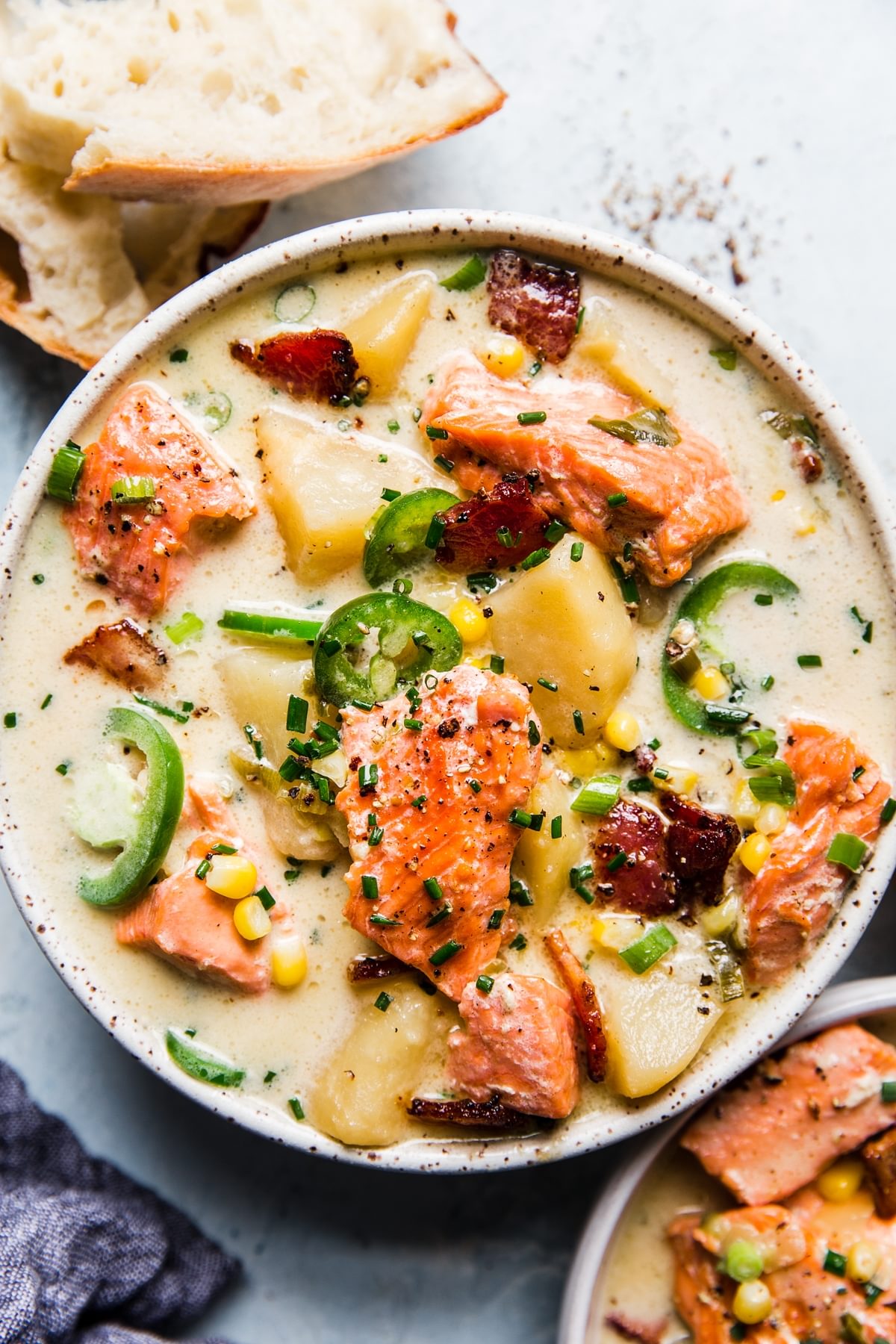 salmon chowder in a bowl with crusty bread on the side