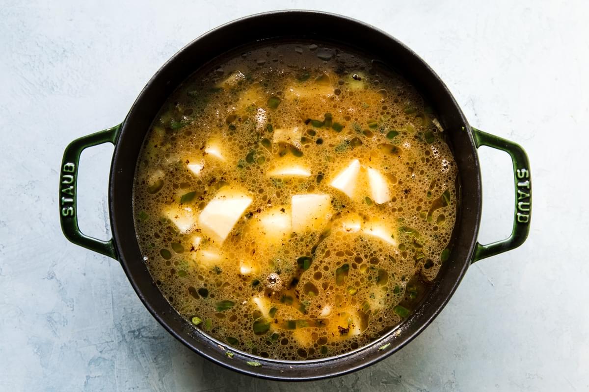 chicken broth with potatoes and vegetables in a stock pot for salmon chowder