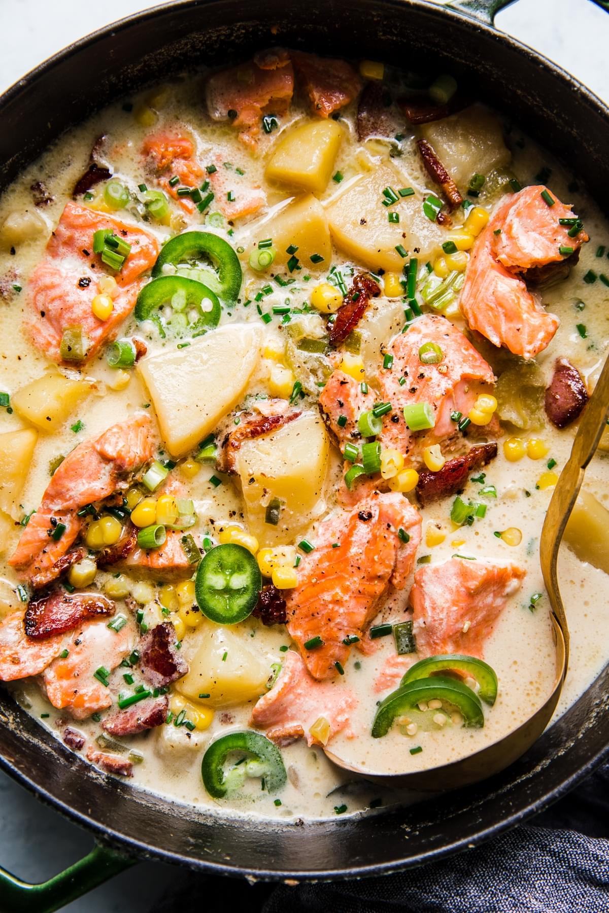 a large pot of salmon chowder with bacon, corn and potatoes