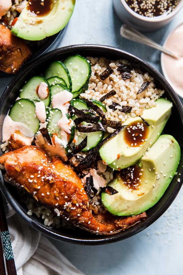 Salmon Sushi Bowl with brown rice, avocado, cucumber, nori, sesame seeds and sriracha mayo