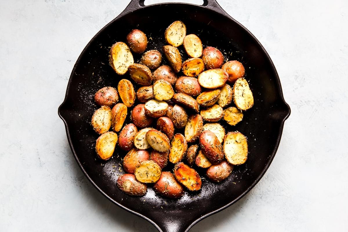 baby red potatoes in a cast iron skillet with   herbs.
