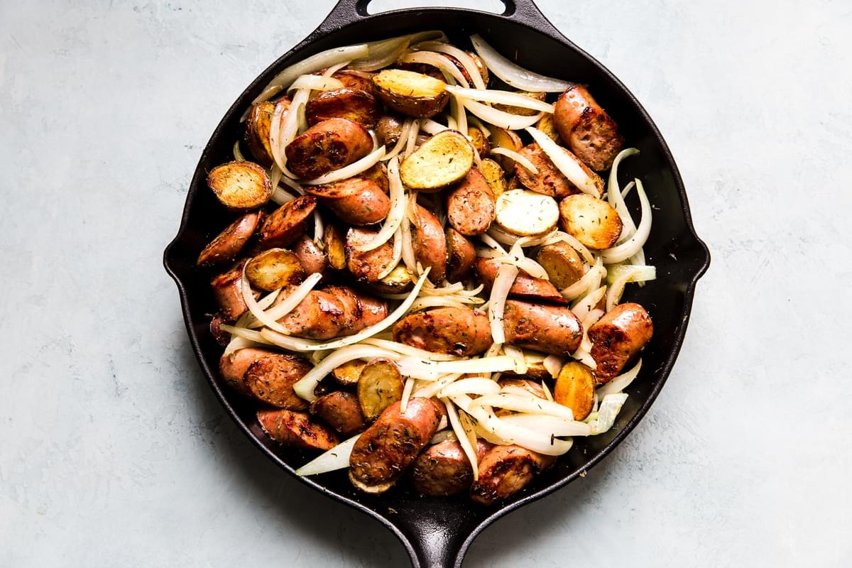 chicken sausage, potatoes and onions in a cast iron skillet