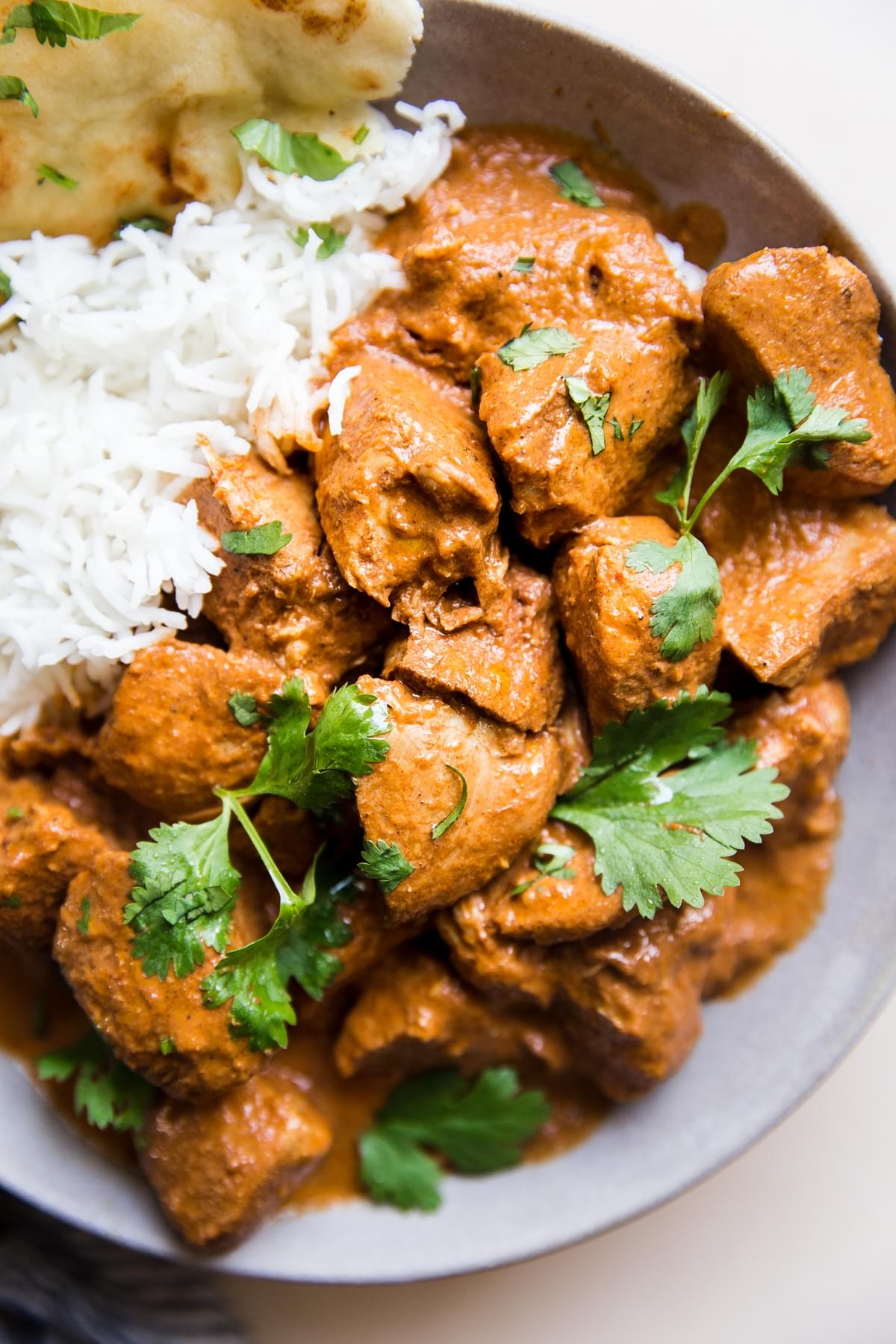 slow cooker butter chicken over rice with cilantro and naan