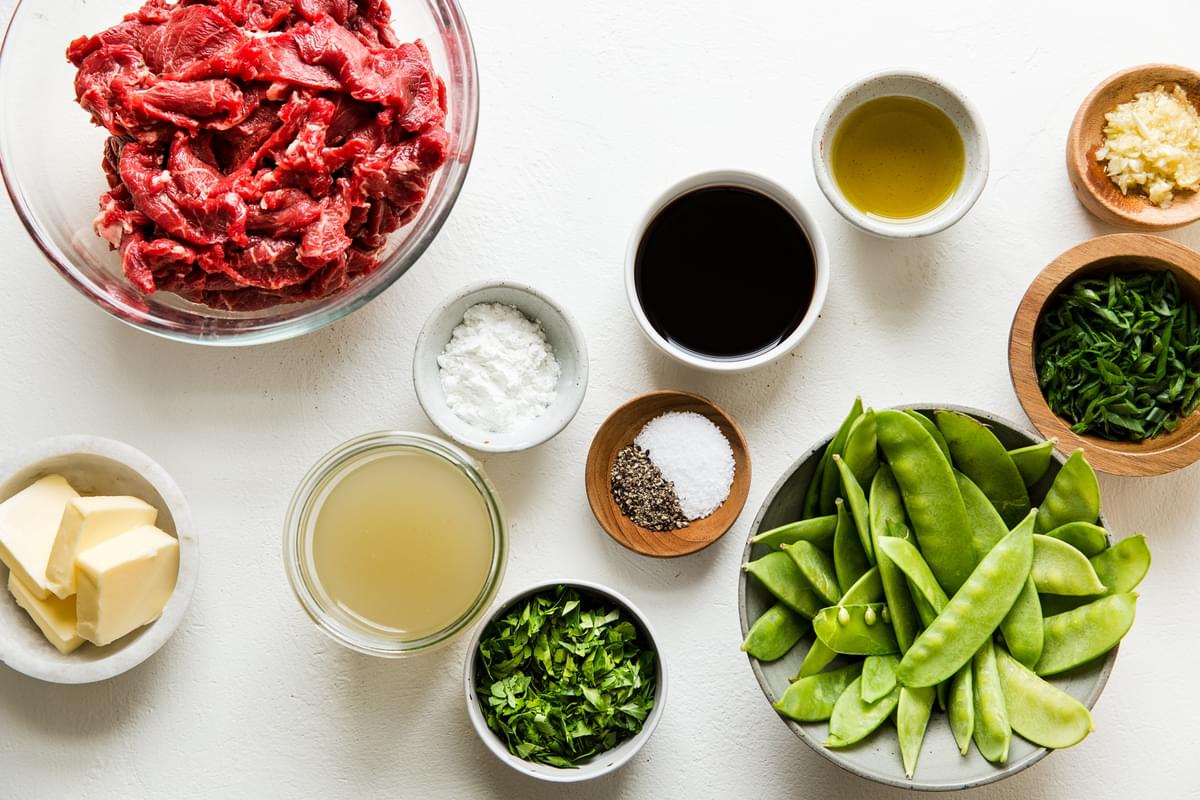 Ingredients laid out for Garlic Butter Steak Stir-Fry snap peas, soy sauce