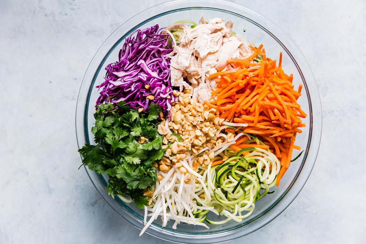 carrots, purple cabbage, chicken, mung beans, zoodles, cilantro and peanuts in a large bowl
