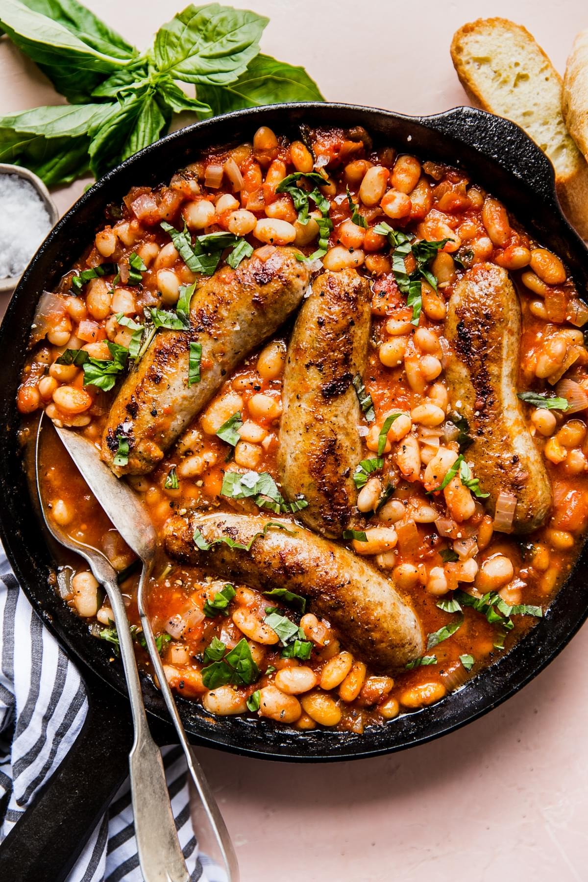 tomato and sausage Cassoulet with basil and white beans in a pan