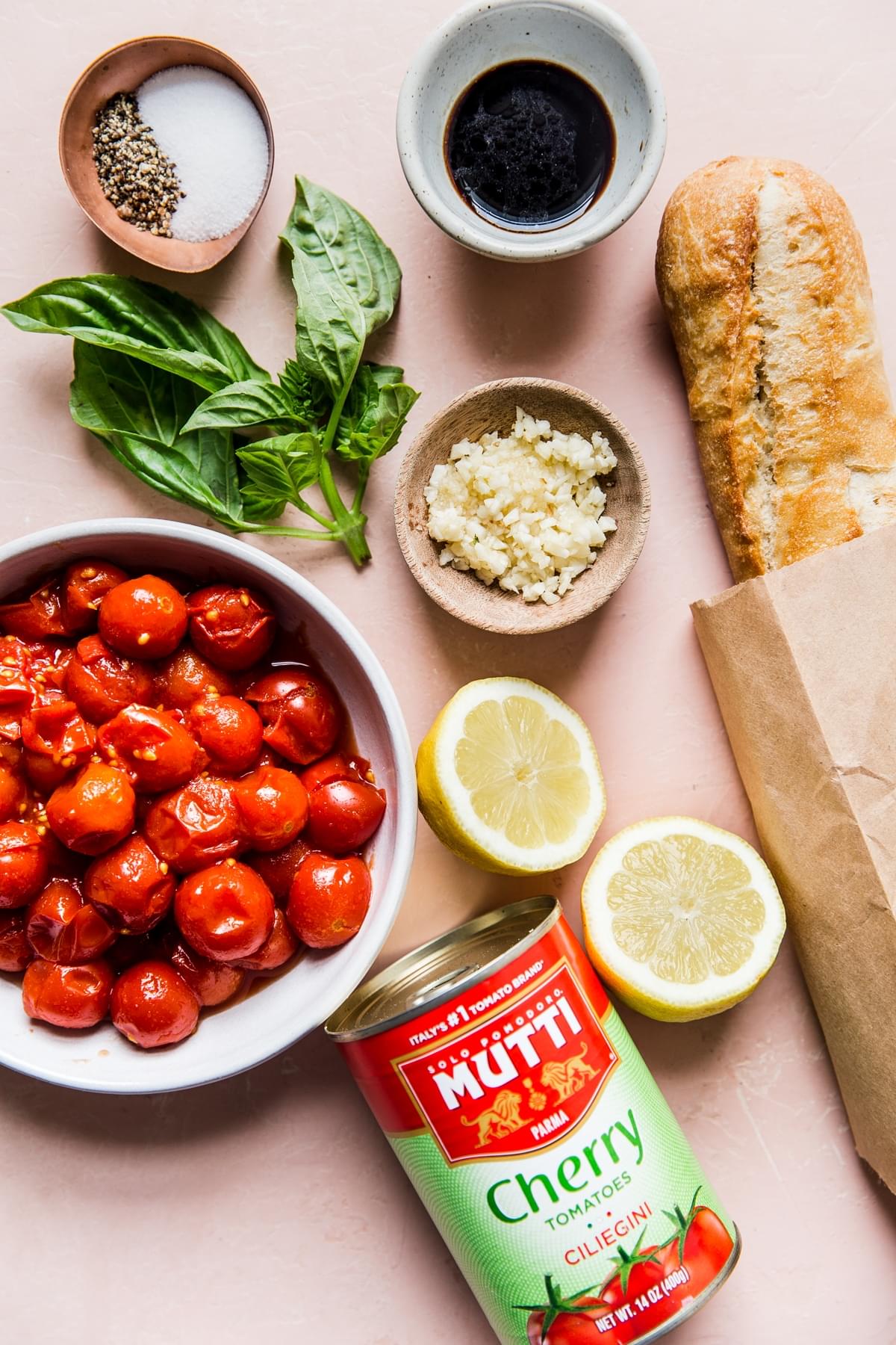 ingredients laid out for tomato Bruschetta balsamic, basil, garlic, lemon bread