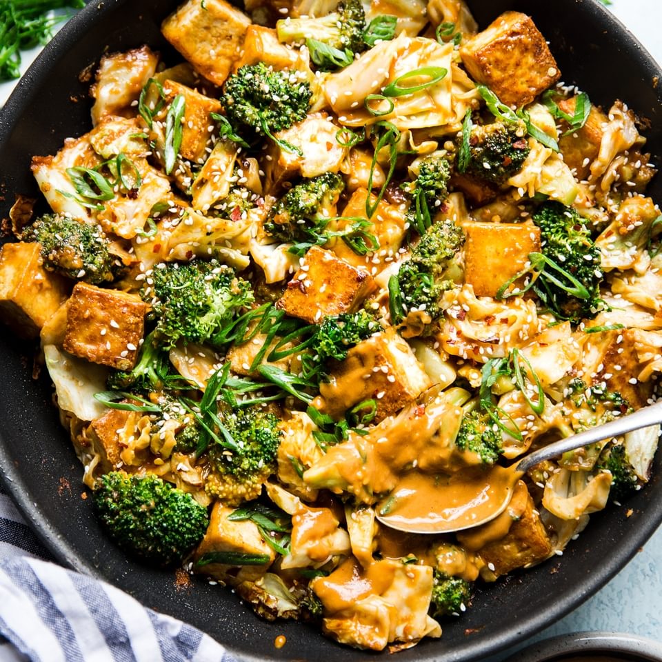 Tofu Stir-Fry with Peanut Sauce in a pan with a spoon