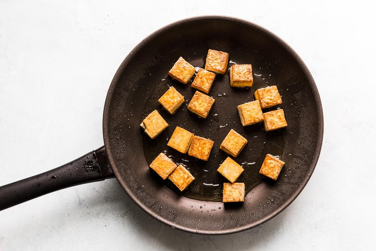 Tofu frying in oil in a pan