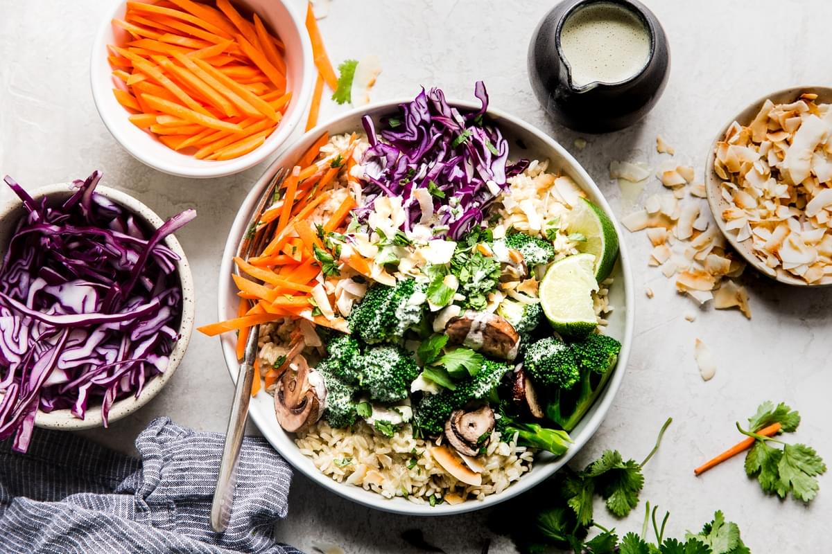 Vegetarian Green Curry Budha Bowl with brown rice, red cabbage, broccoli, mushrooms, carrots and toasted coconut in a bowl