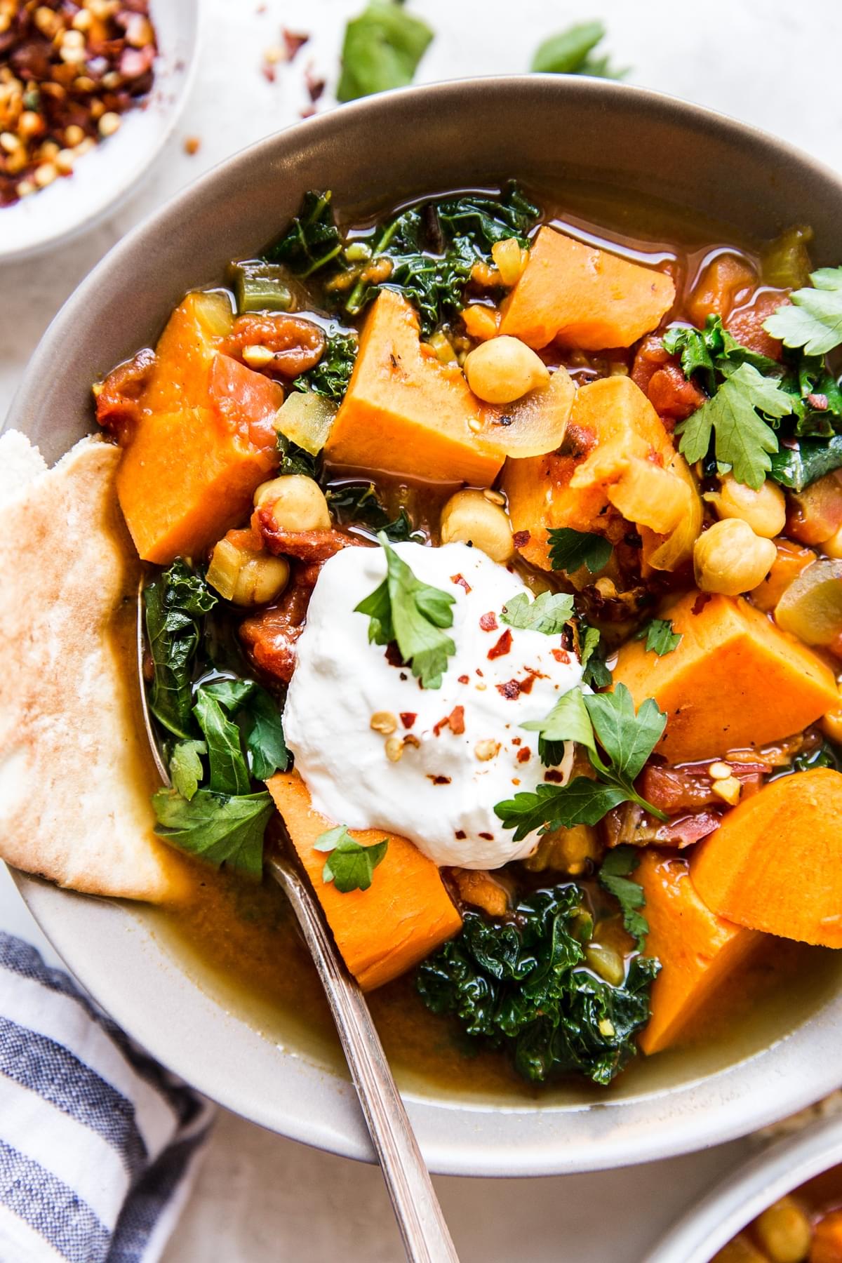 Warm Spiced Vegetarian Vegetable Stew in a bowl with sweet potatoes, and kale