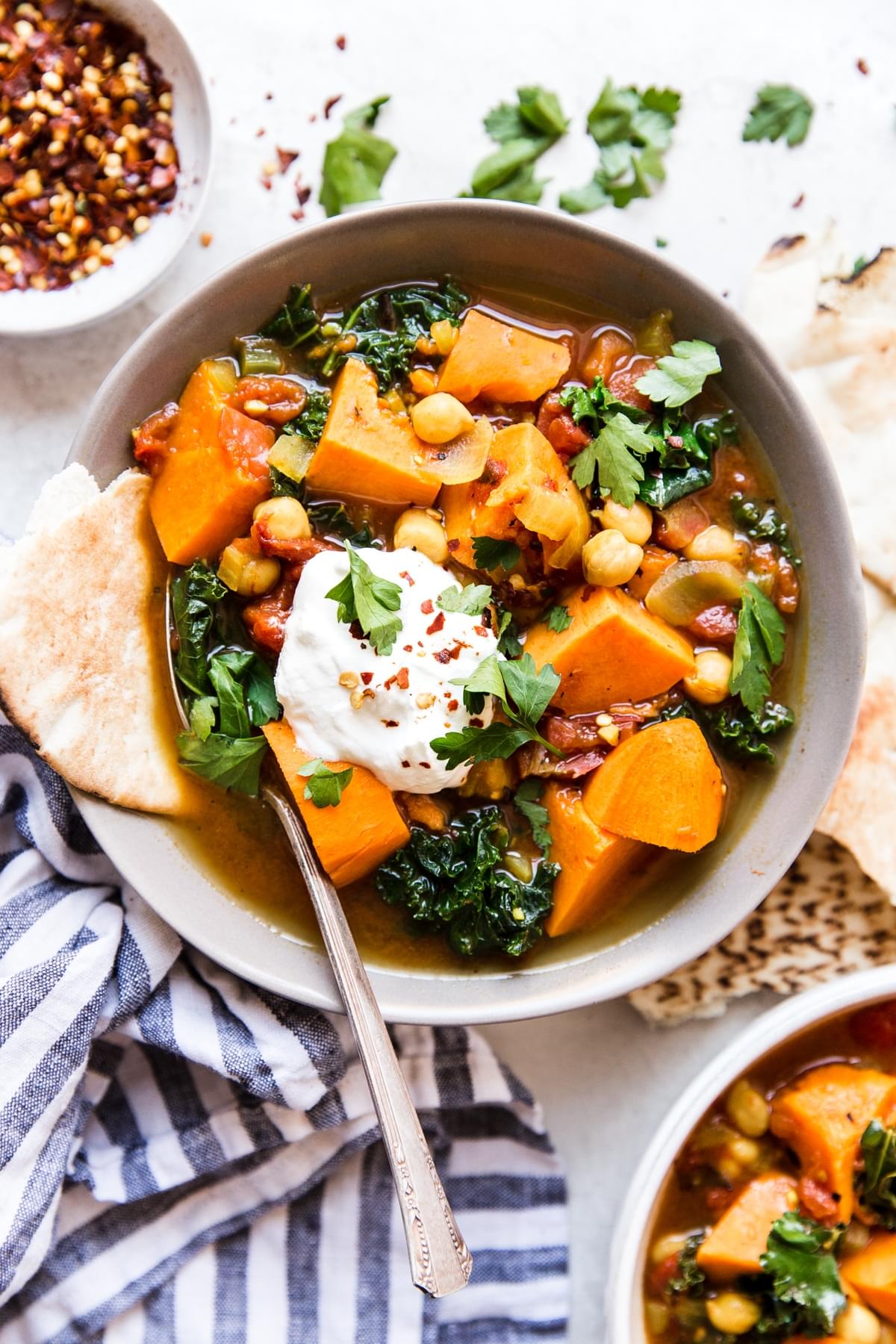 Warm Spiced Vegetarian Vegetable Stew in a bowl with a spoon and pita bread