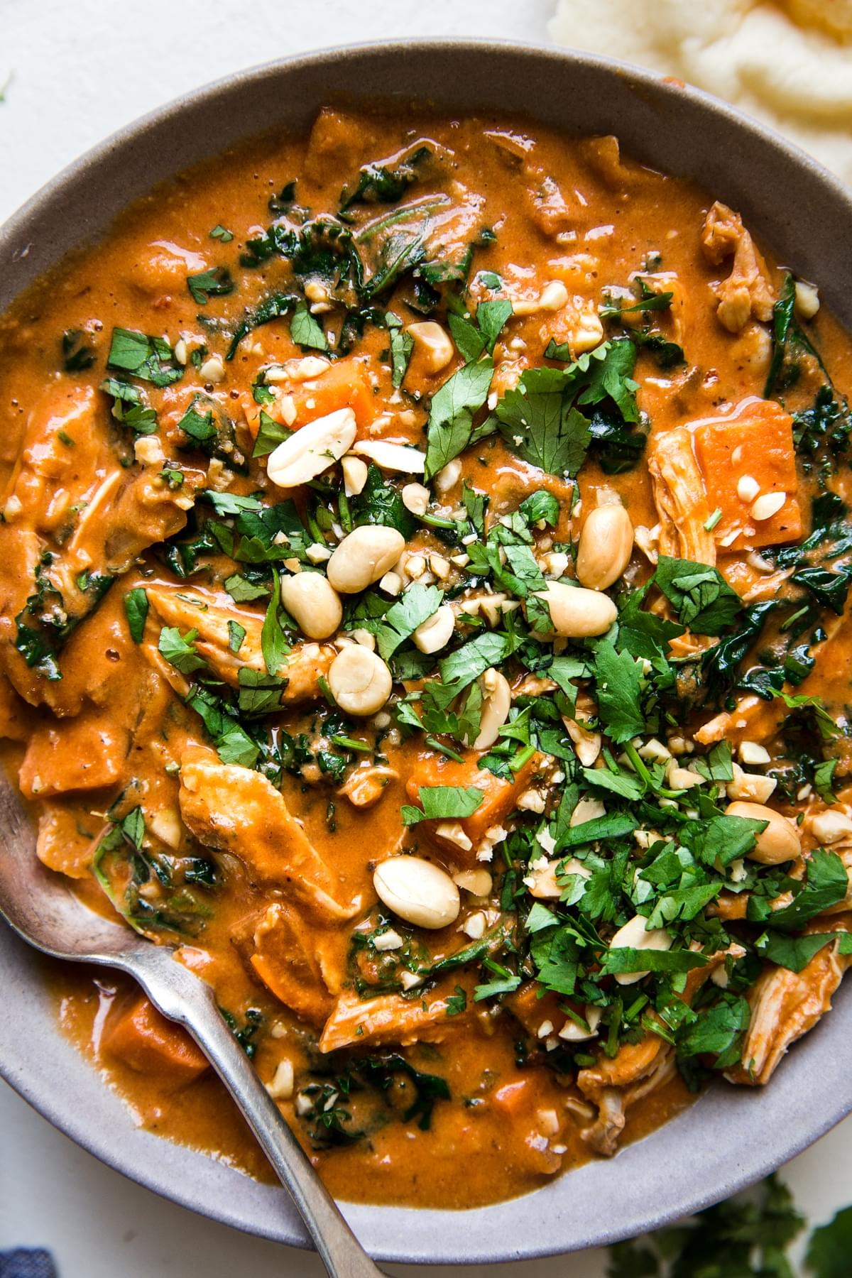 bowl of African peanut soup topped with fresh cilantro and chopped peanuts
