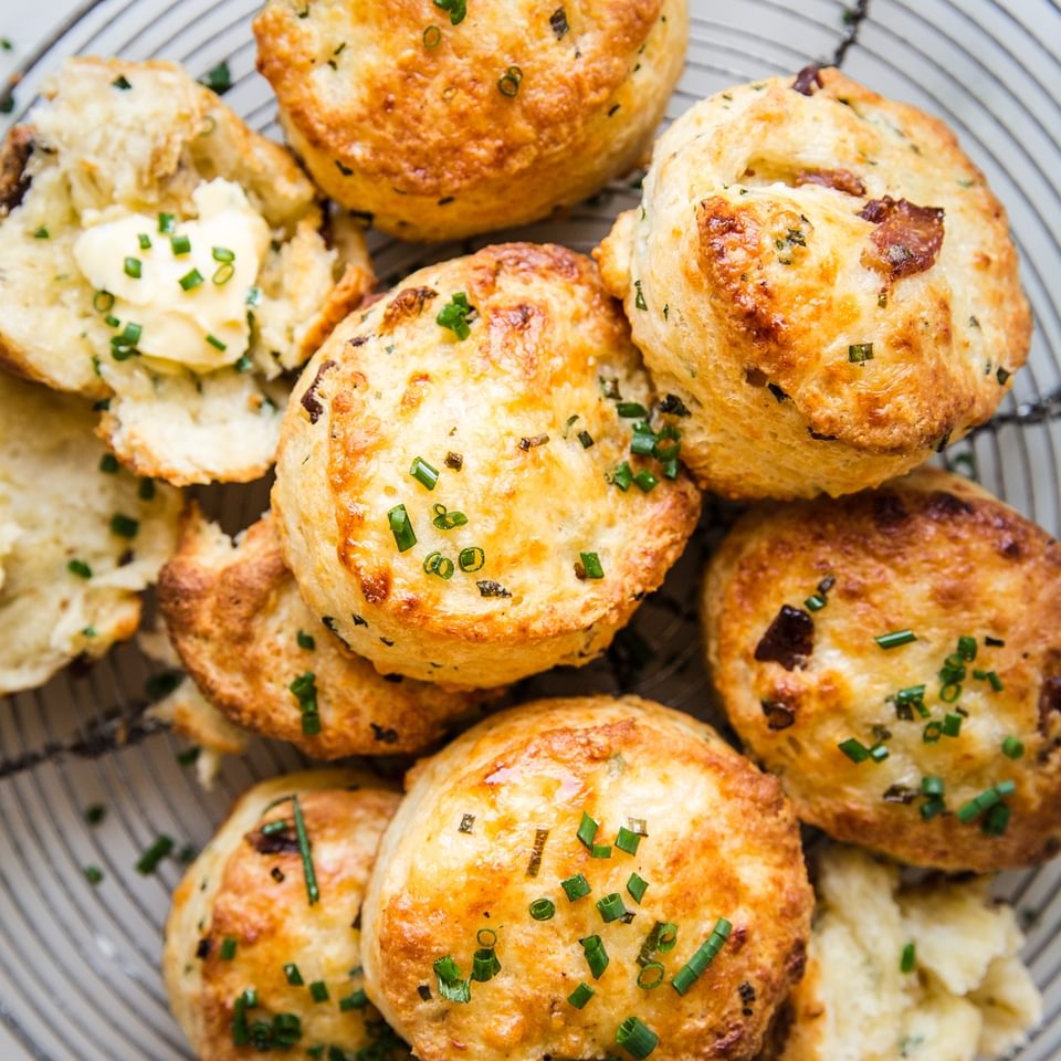 bacon cheddar buttermilk biscuit recipe with chives and butter on a wire baking rack