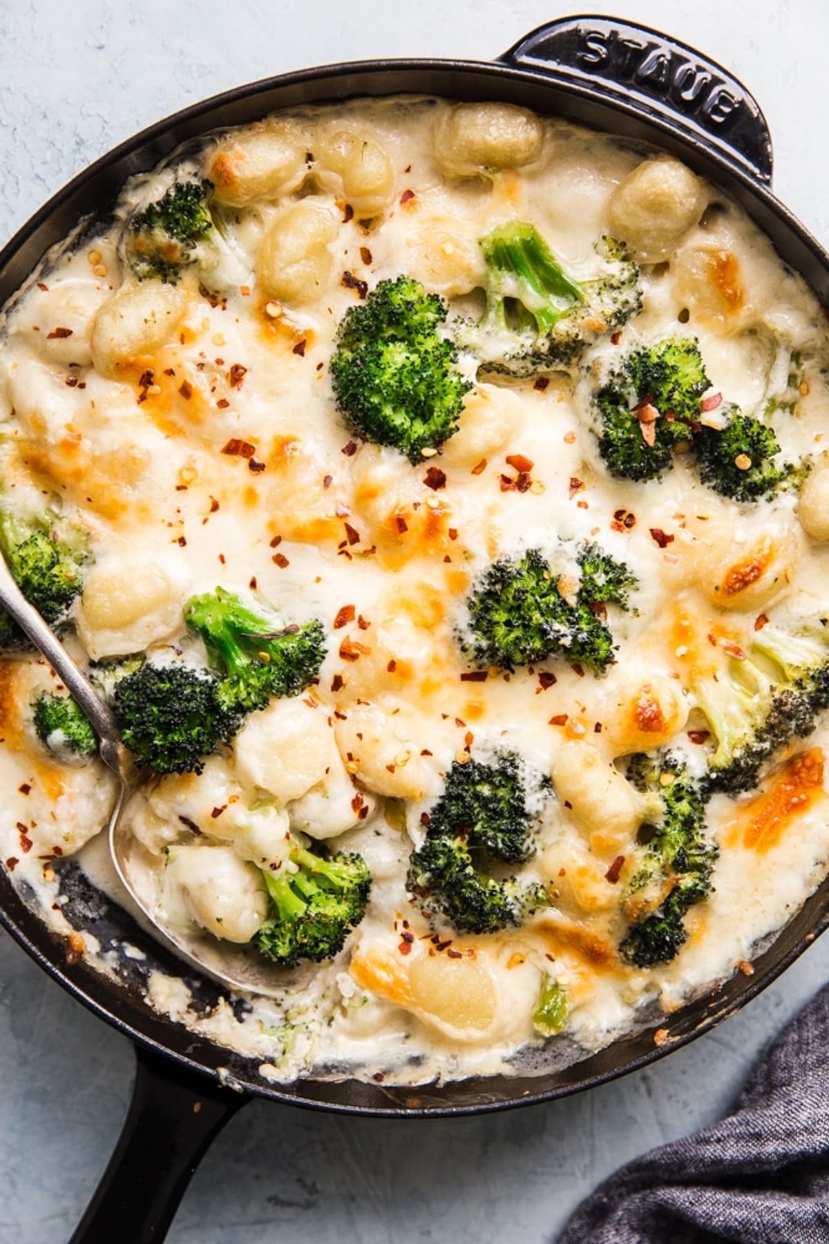 cheesy Baked Gnocchi with broccoli in a cast iron skillet