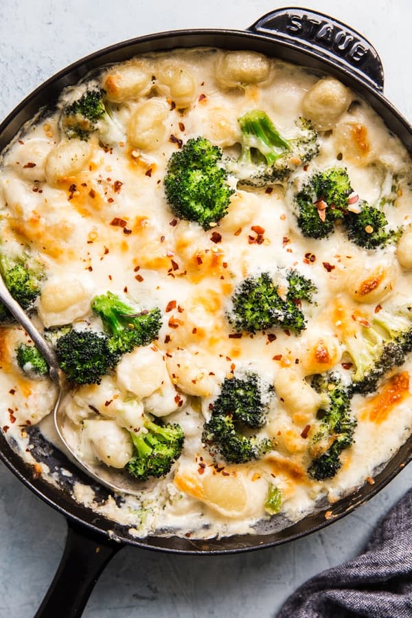 cheesy Baked Gnocchi with broccoli in a cast iron skillet